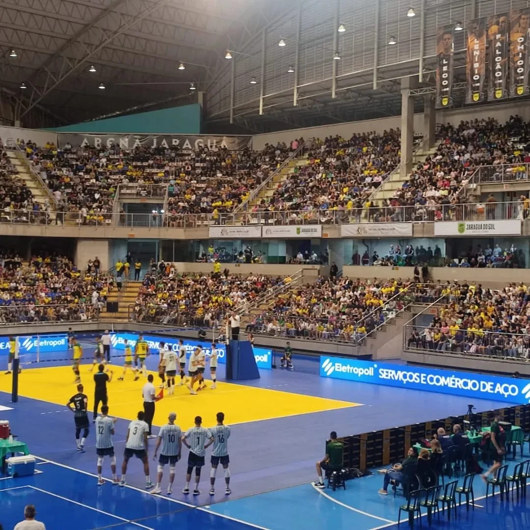 Jogo de futsal e arquibancadas cheias na Arena Jaraguá